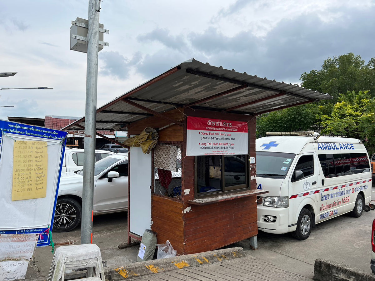 Check-in reference: small brown wooden booth with a corrugated metal roof at Bang Rong Pier, Phuket