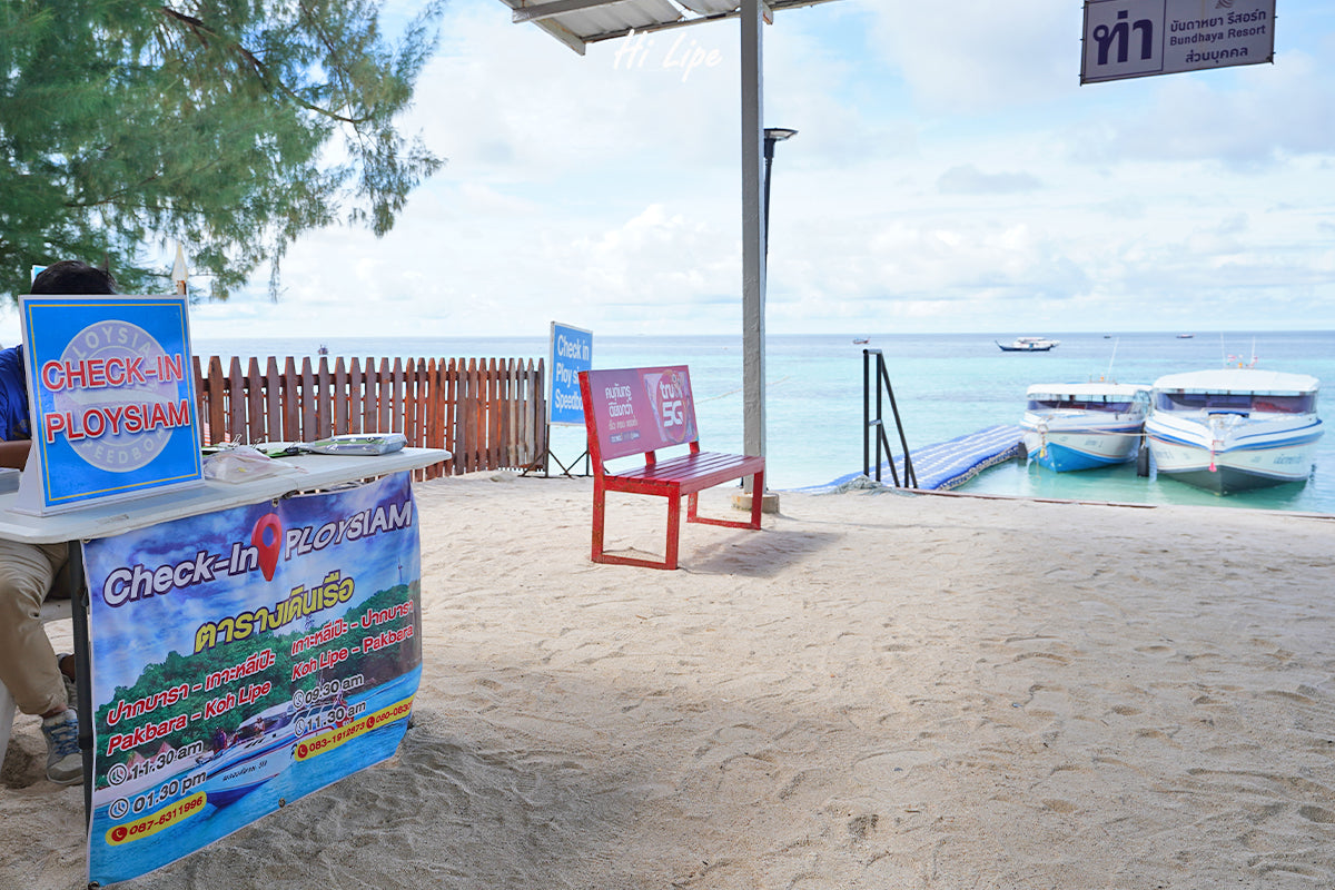Ploysiam check-in desk at Koh Lipe pier with speedboat schedule board for Koh Lipe to Pak Bara route