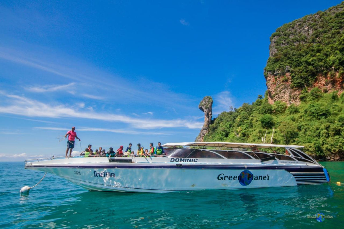 Boat with passengers on a clear day near a rocky island