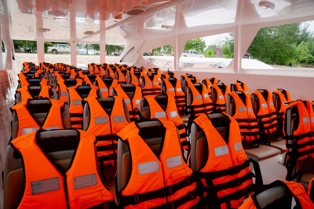 Row of orange life vests on a boat interior with seats.