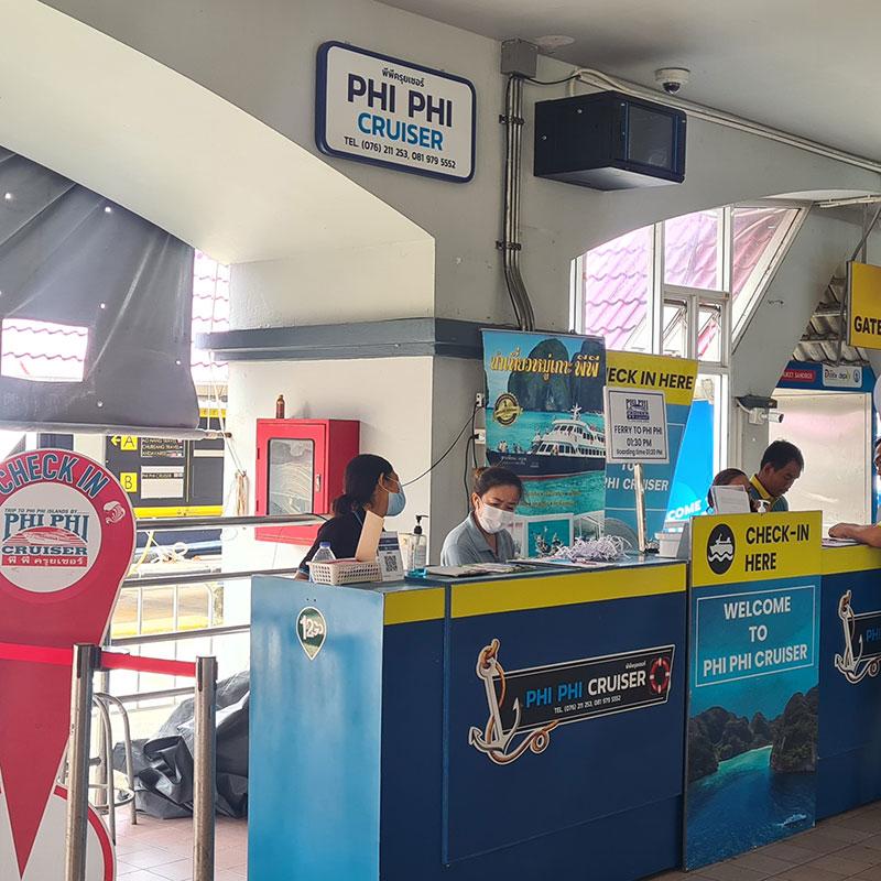 Phi Phi Cruiser check-in counter with staff and yellow check-in signs