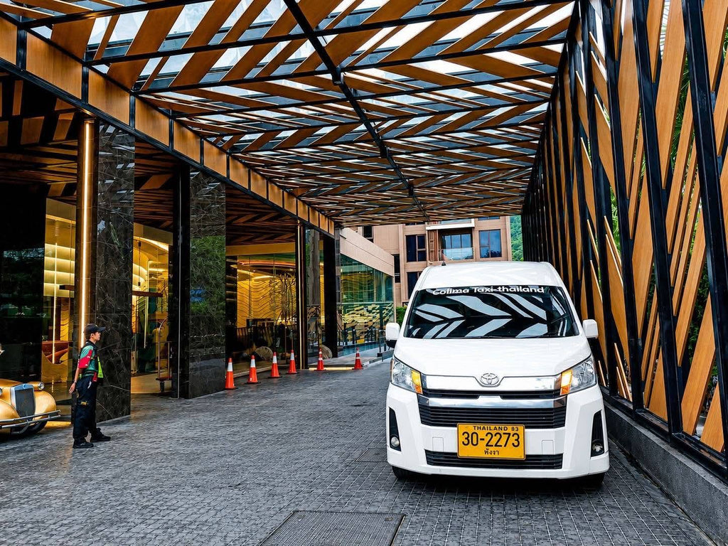White Toyota passenger van parked beneath a covered hotel entrance