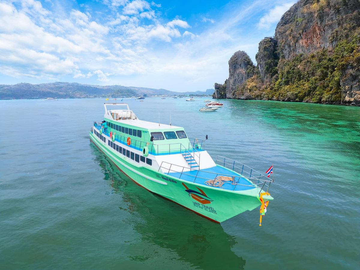 Green Urip Travel passenger ferry near limestone cliffs at Koh Phi Phi